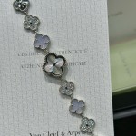Van Cleef & Arpels watch with silver dial, diamond-set clover motif, and white mother-of-pearl.